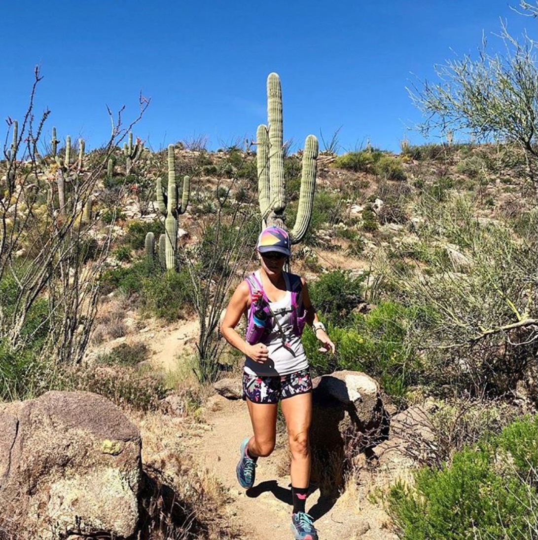Photo of myself running on a trail in the desert.